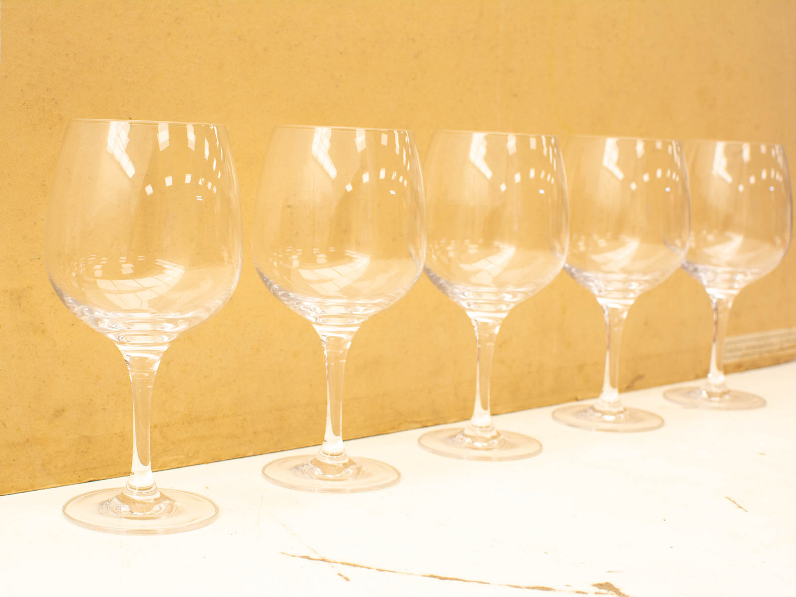 Elegant wine glasses on a warm yellow background, perfect for any celebration or gathering.