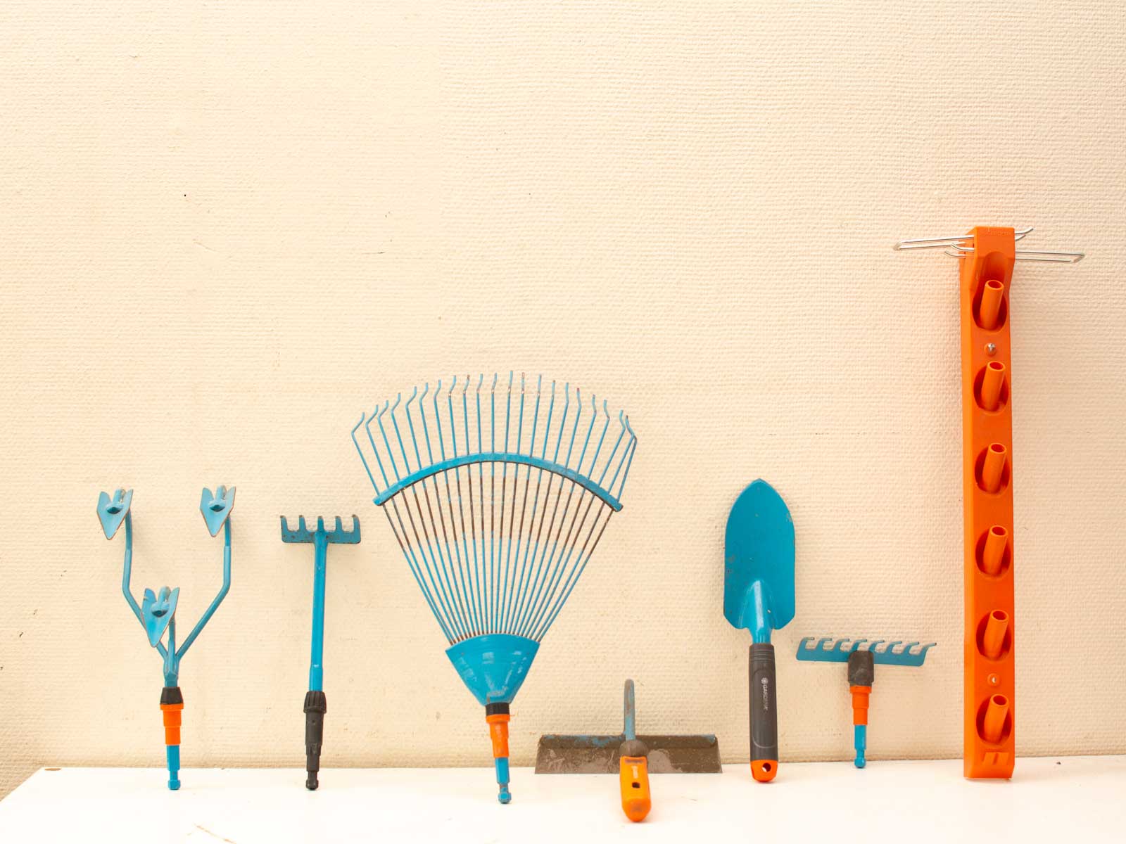 Vibrant blue gardening tools with orange accents, neatly organized for easy access and storage.