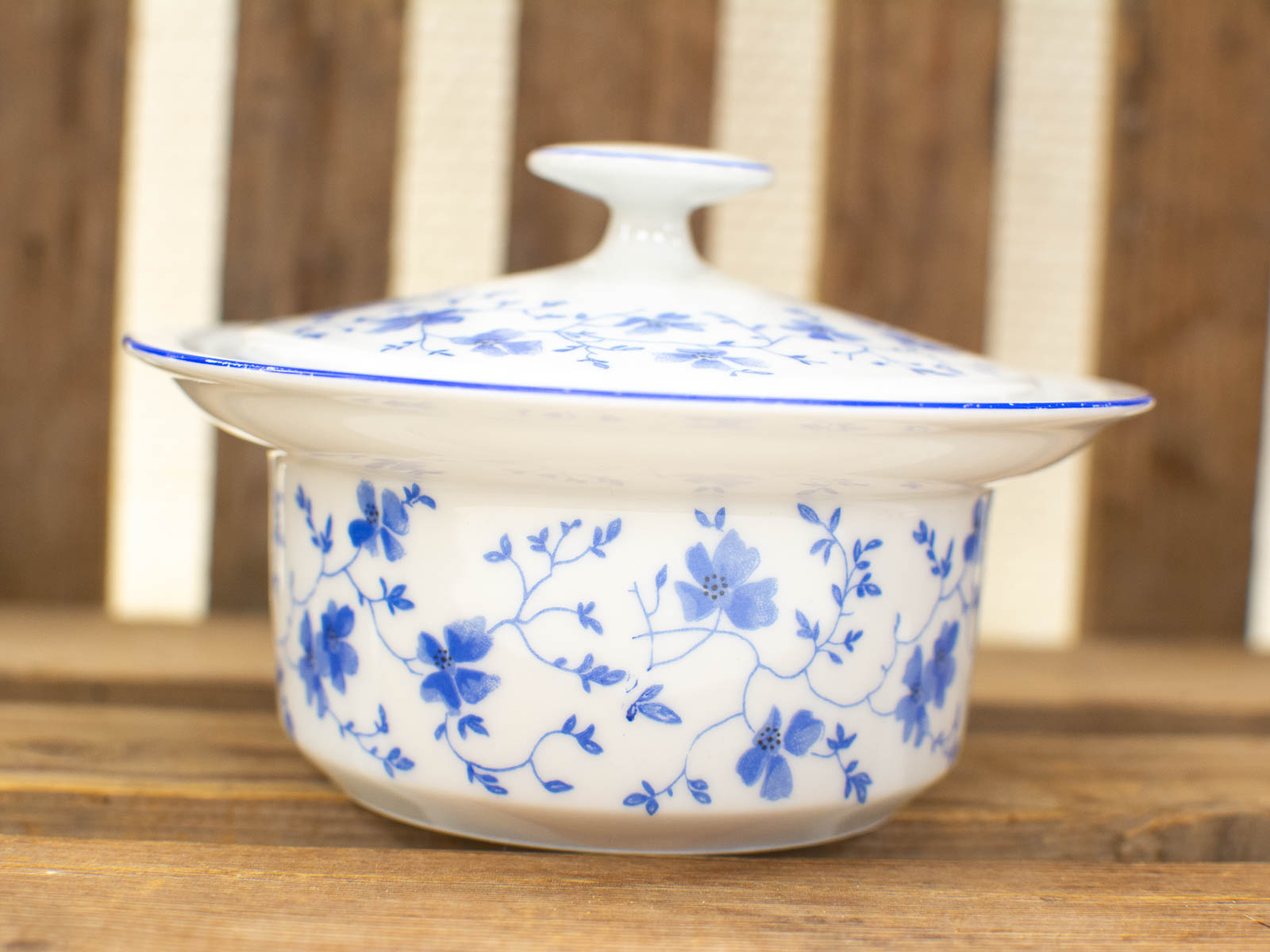 Elegant vintage porcelain covered dish with blue floral design on white glaze, perfect for serving.