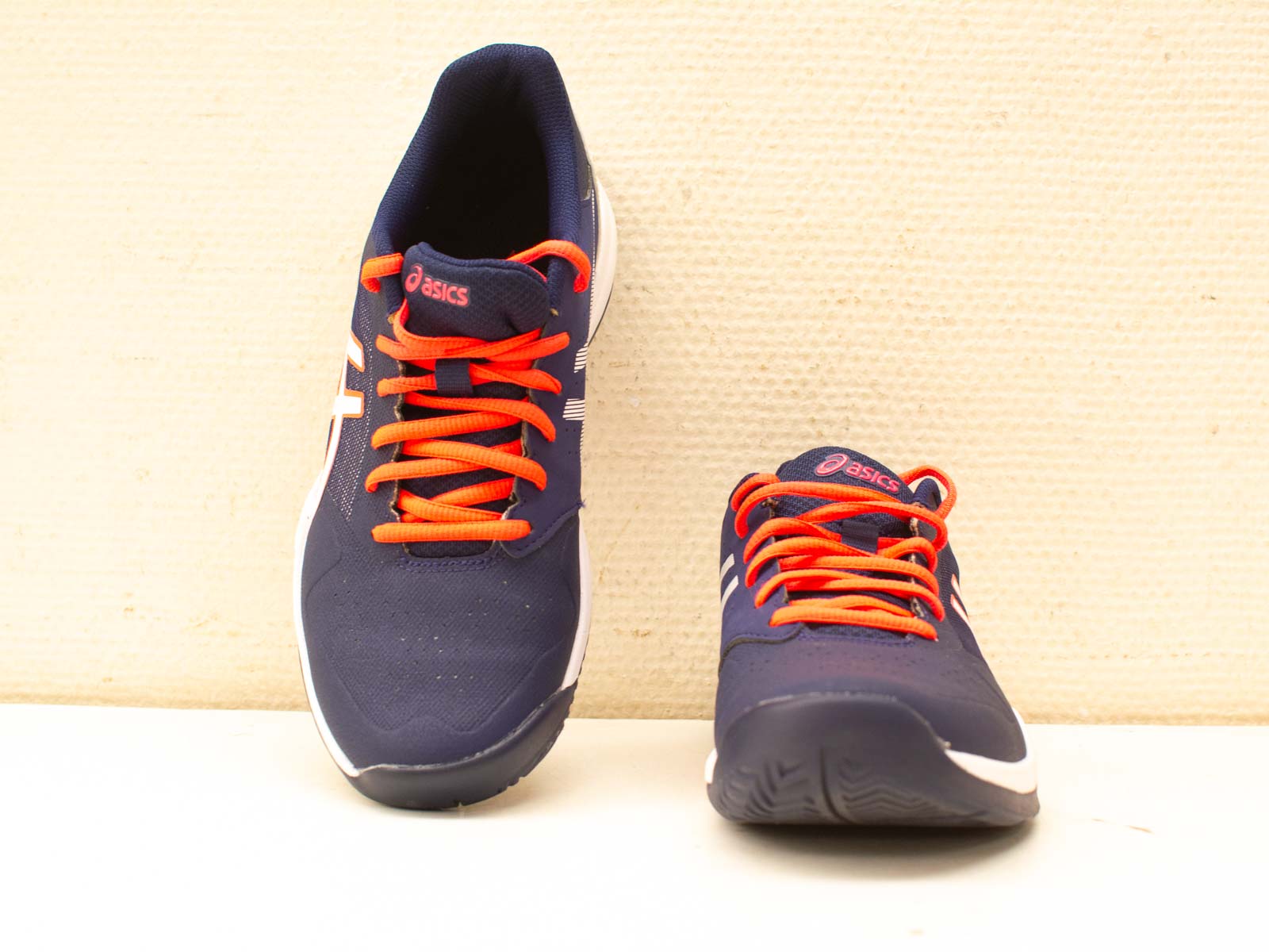 Asics navy blue athletic shoes with orange laces for comfort and performance in any activity.