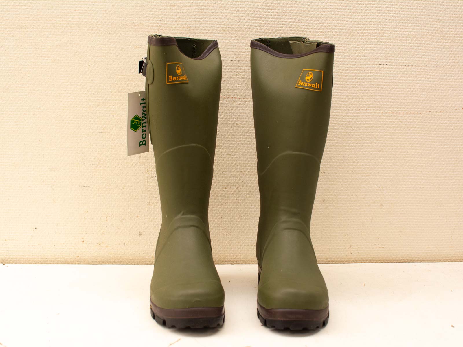 Stylish olive green rubber boots with brown trim, perfect for outdoor activities and wet conditions.