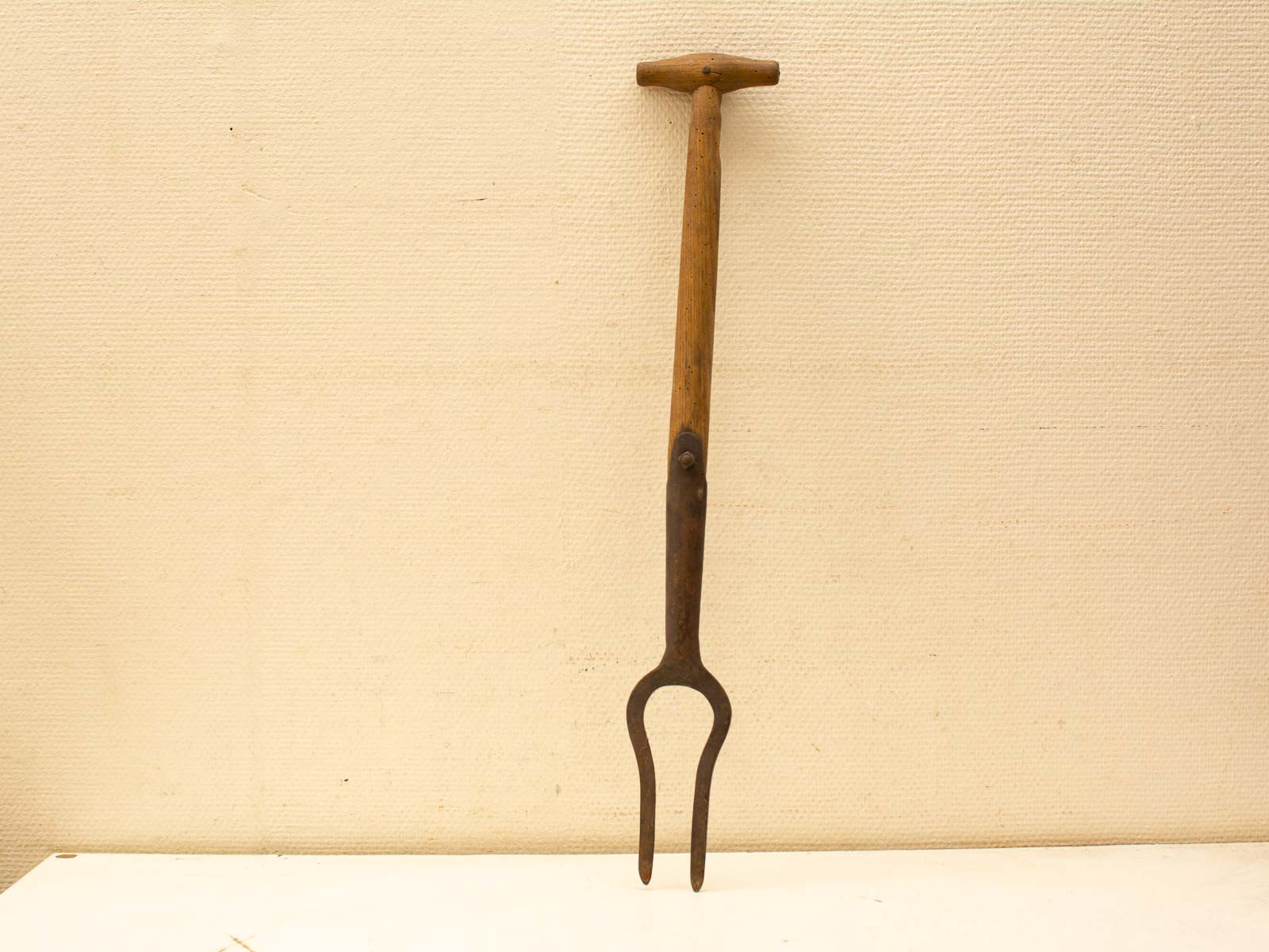 Vintage garden fork with wooden handle and metal prongs, perfect for gardening tasks.