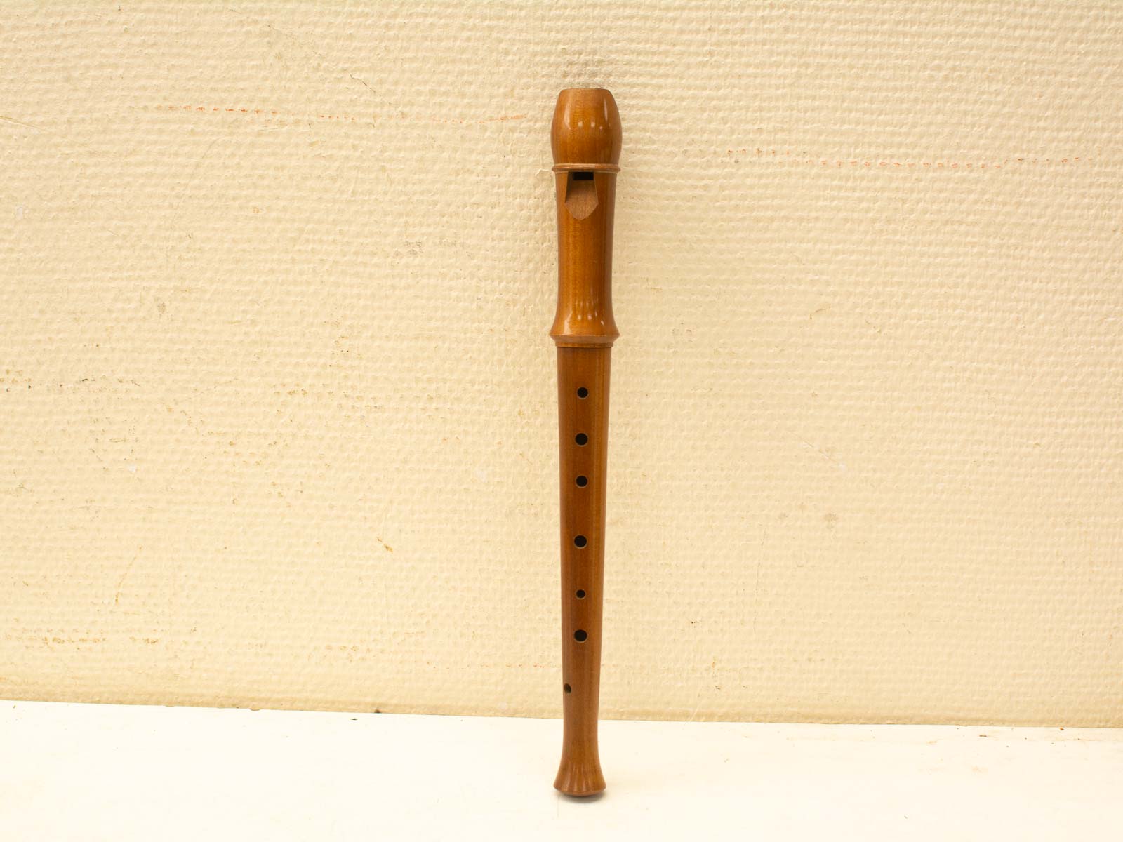 Classic wooden recorder with finger holes, a timeless instrument reflecting historic musical craftsmanship.