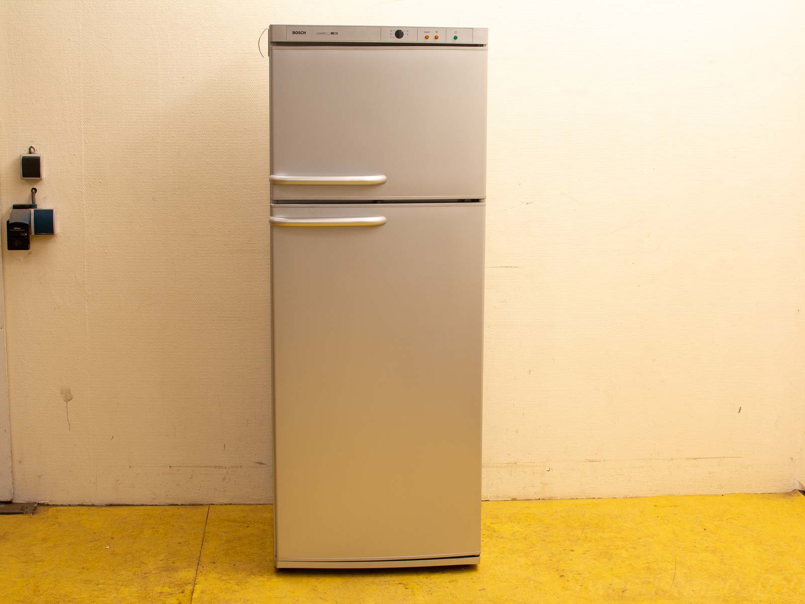 Sleek vintage metal refrigerator with double doors, modern elegance, and convenient control features.