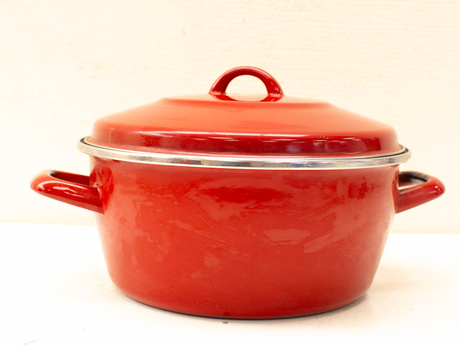 Quality vintage red cooking pot, perfect for stews and soups, with durable handles and lid.