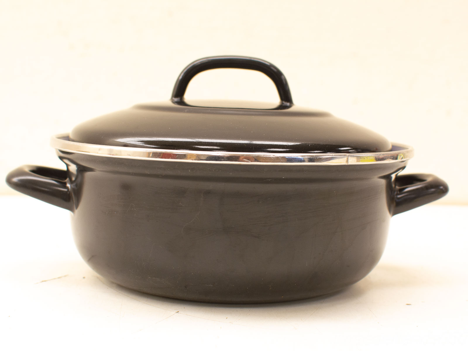 Elegant black cooking pot with silver rim, perfect for stylish everyday cooking and gatherings.