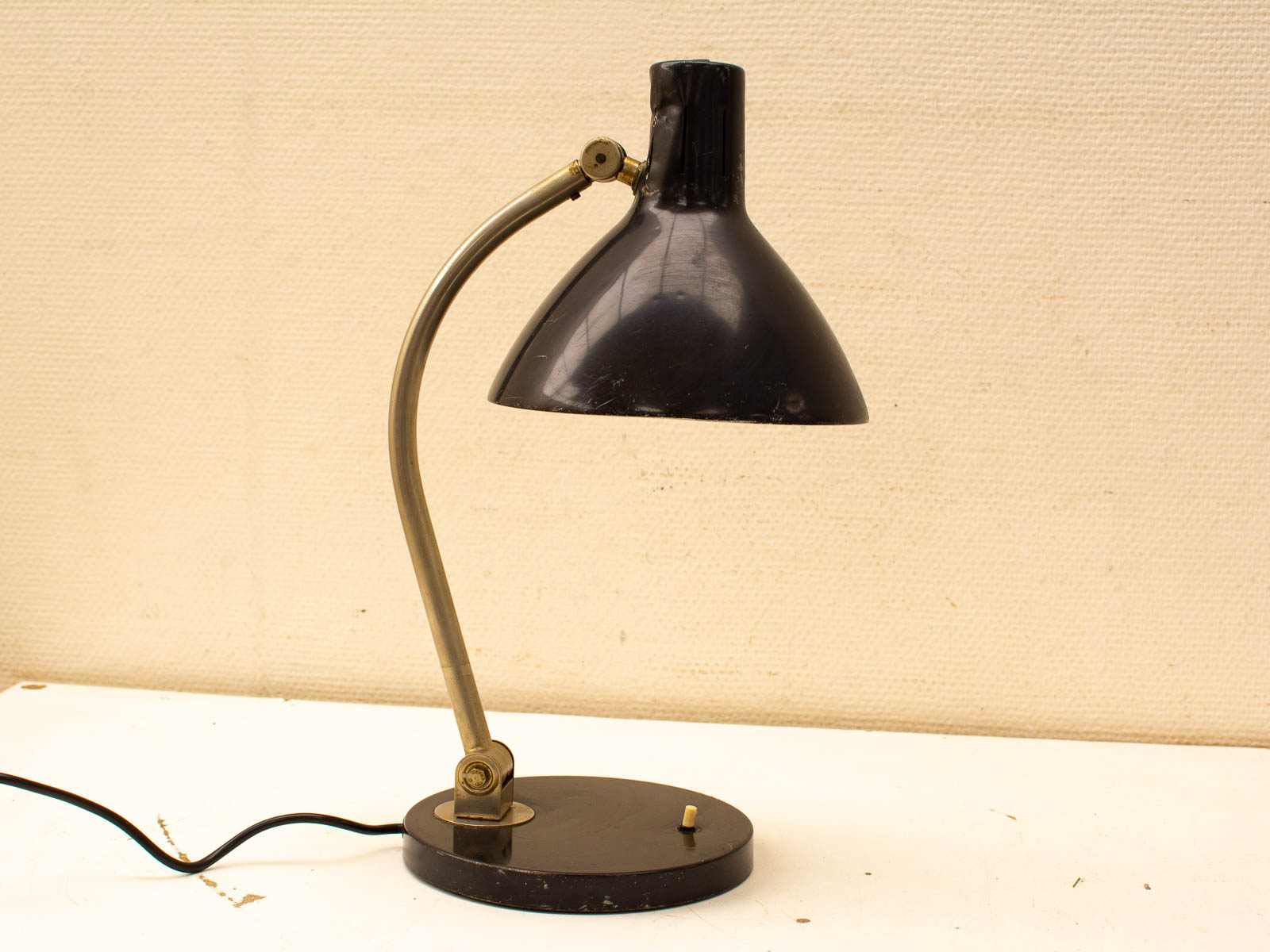 Sleek vintage desk lamp with black cone shade and metallic arm, perfect for stylish interiors.