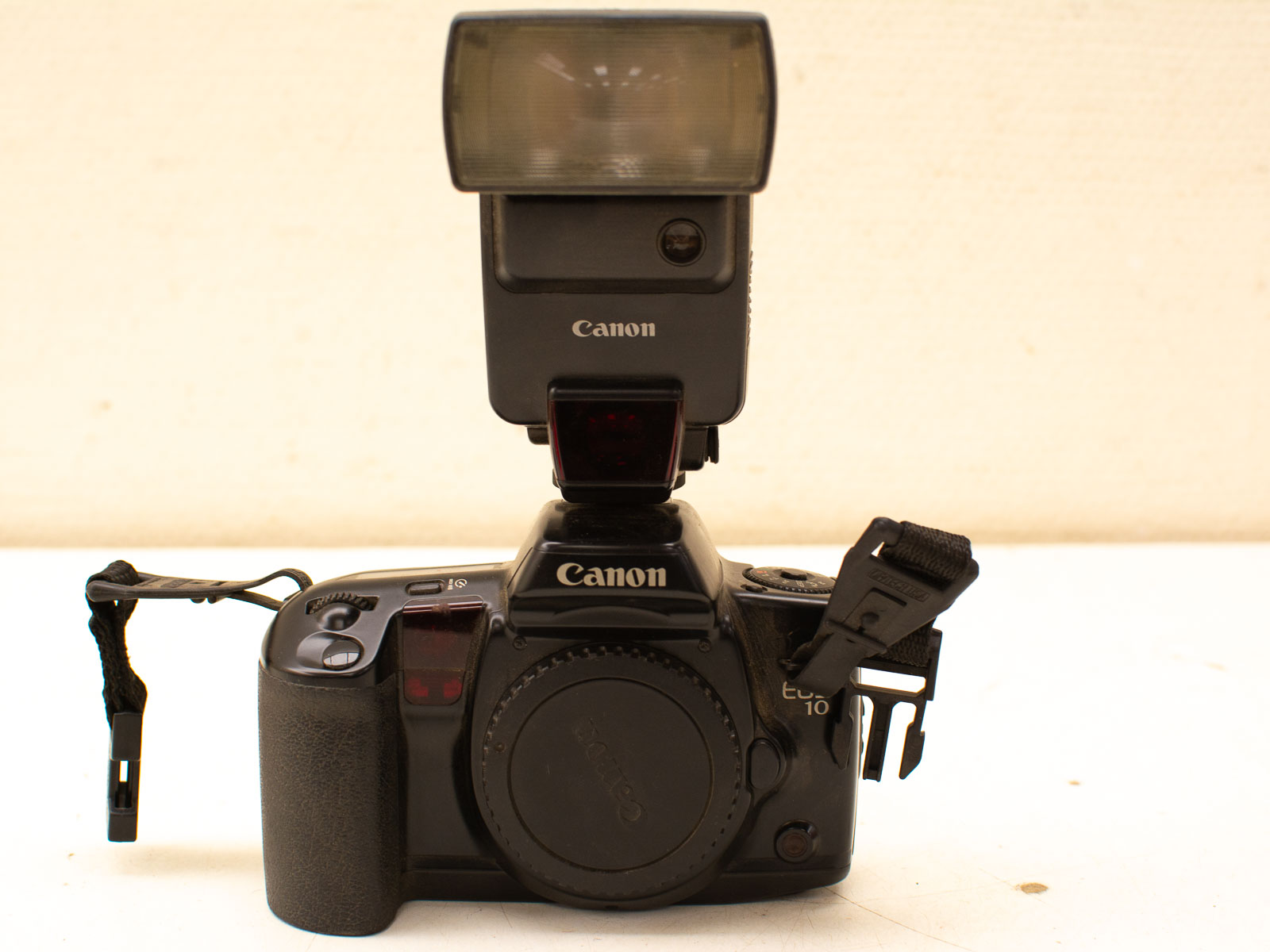 Vintage Canon EOS 10 camera with flash unit, perfect for photography enthusiasts and collectors.