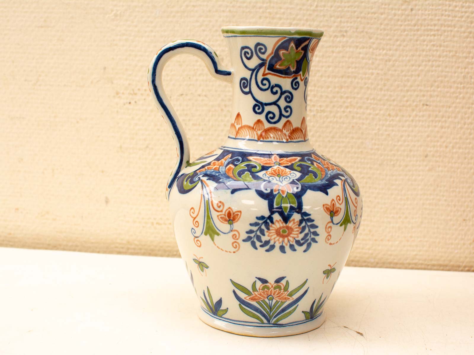 Vibrant ceramic jug with intricate floral patterns in rich colors, blending functionality and artistry.