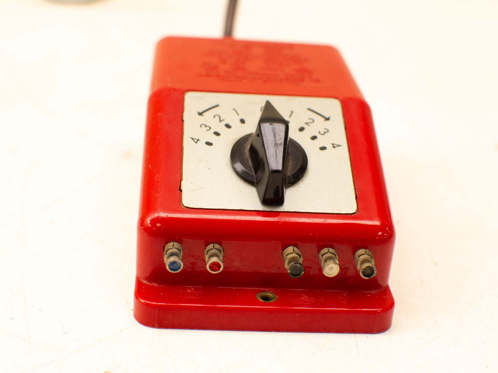 Compact red electronic device with adjustable knob and color-coded ports for versatile connections.