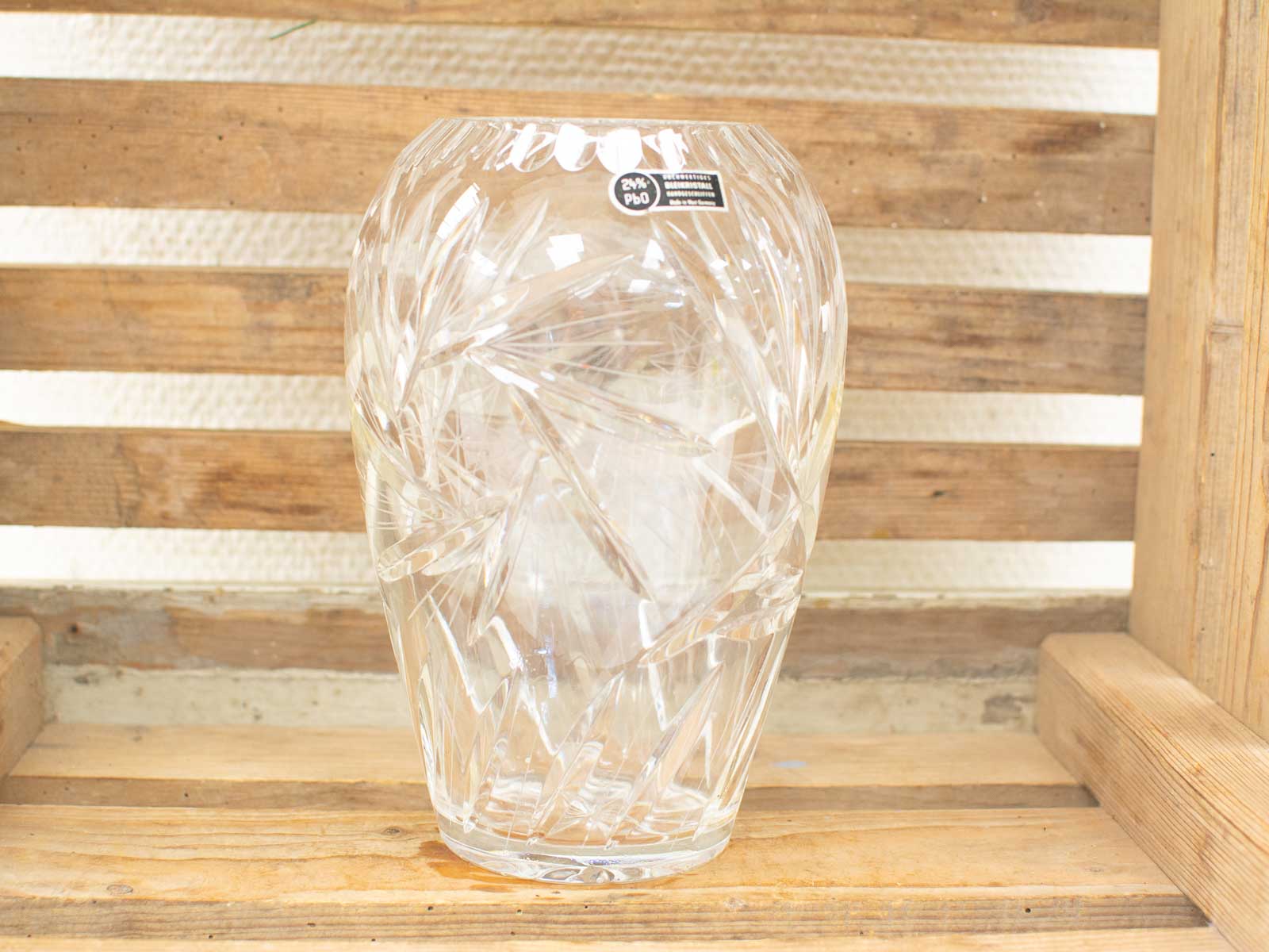 Elegant crystal vase with geometric patterns, perfect centerpiece on rustic wooden surface.