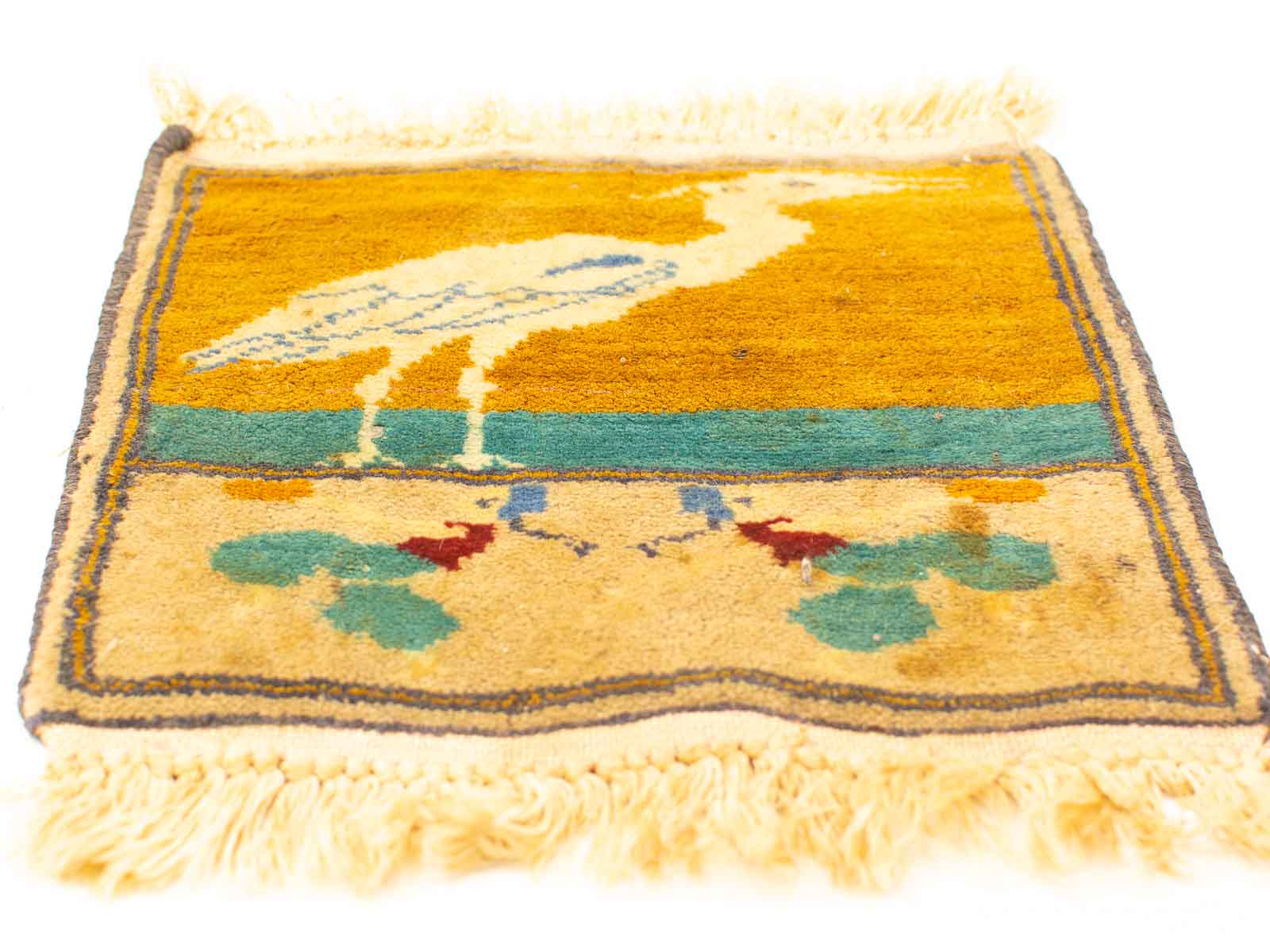 Handmade textile art featuring a stylized bird and vibrant floral motifs in a decorative rug design.