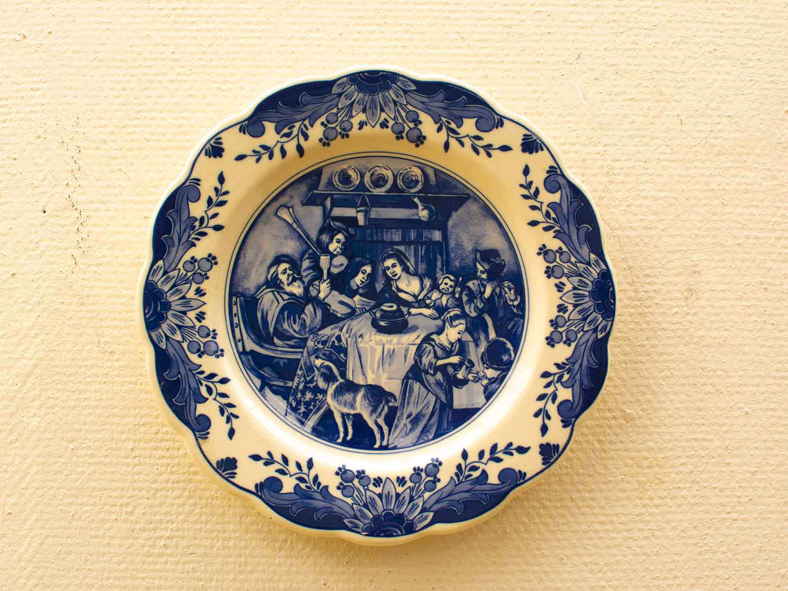 Vintage blue-and-white plate depicting a joyful family gathering around a dining table.