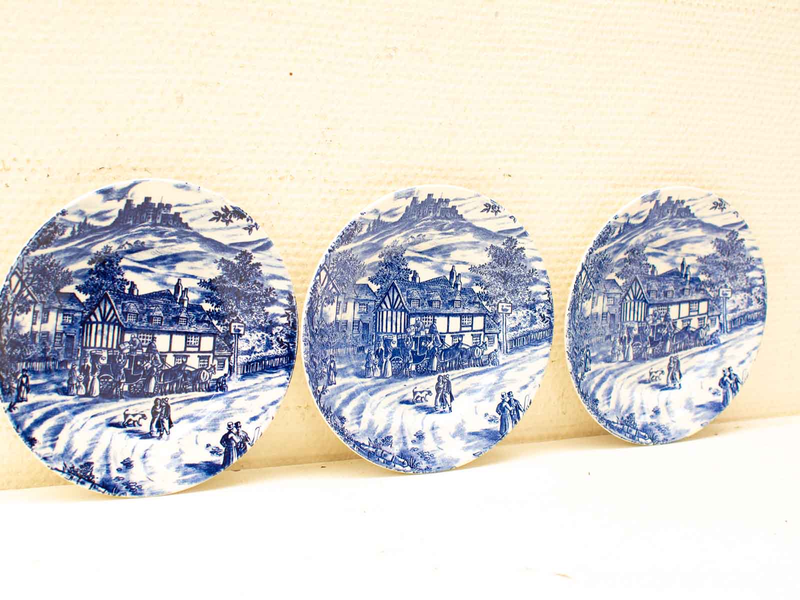 Vintage blue and white decorative plates featuring charming rural landscape scenes. Perfect for collectors!