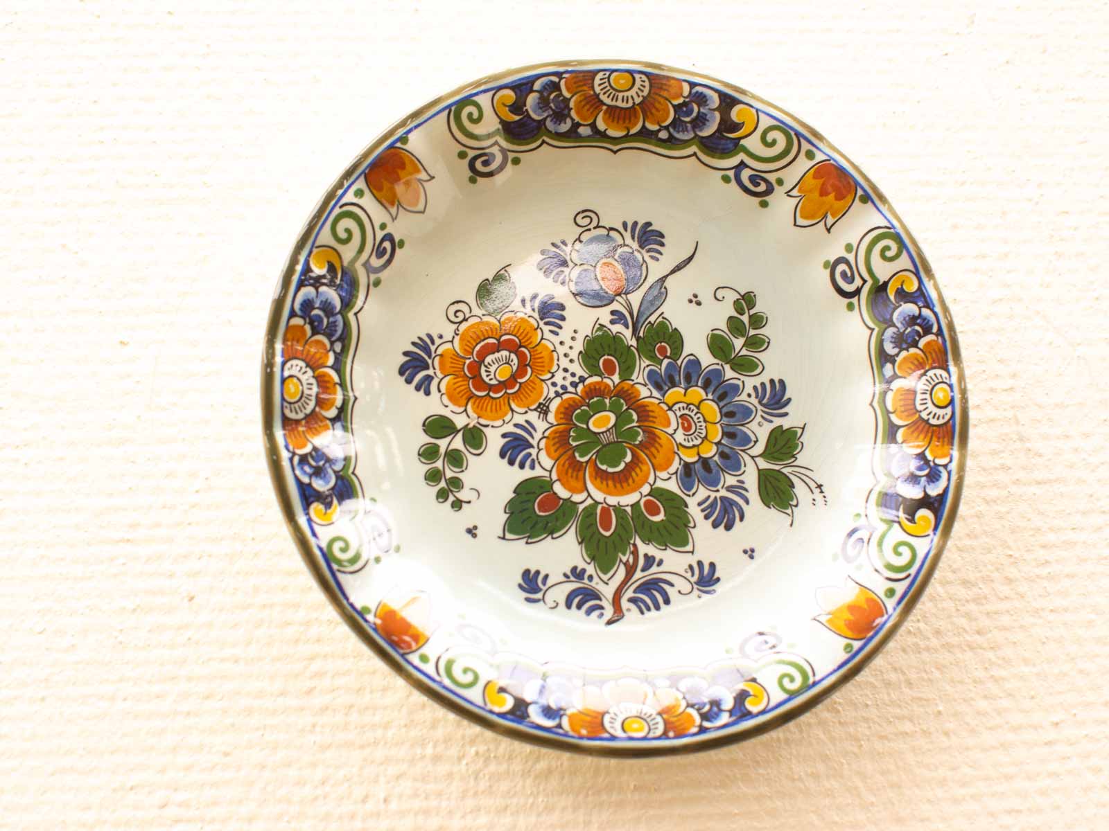 Hand-painted ceramic plate featuring vibrant floral designs in traditional pottery style.