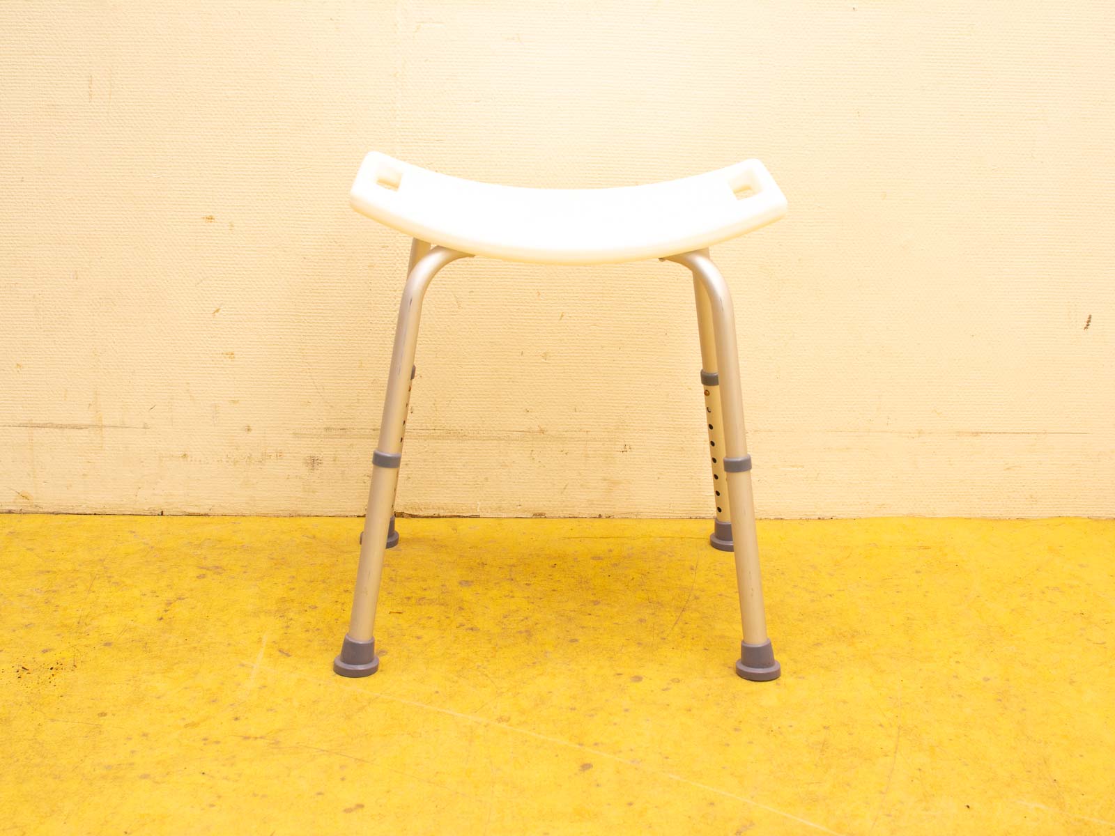 Modern white stool with metal legs, ergonomic design, perfect for kitchens and versatile spaces.