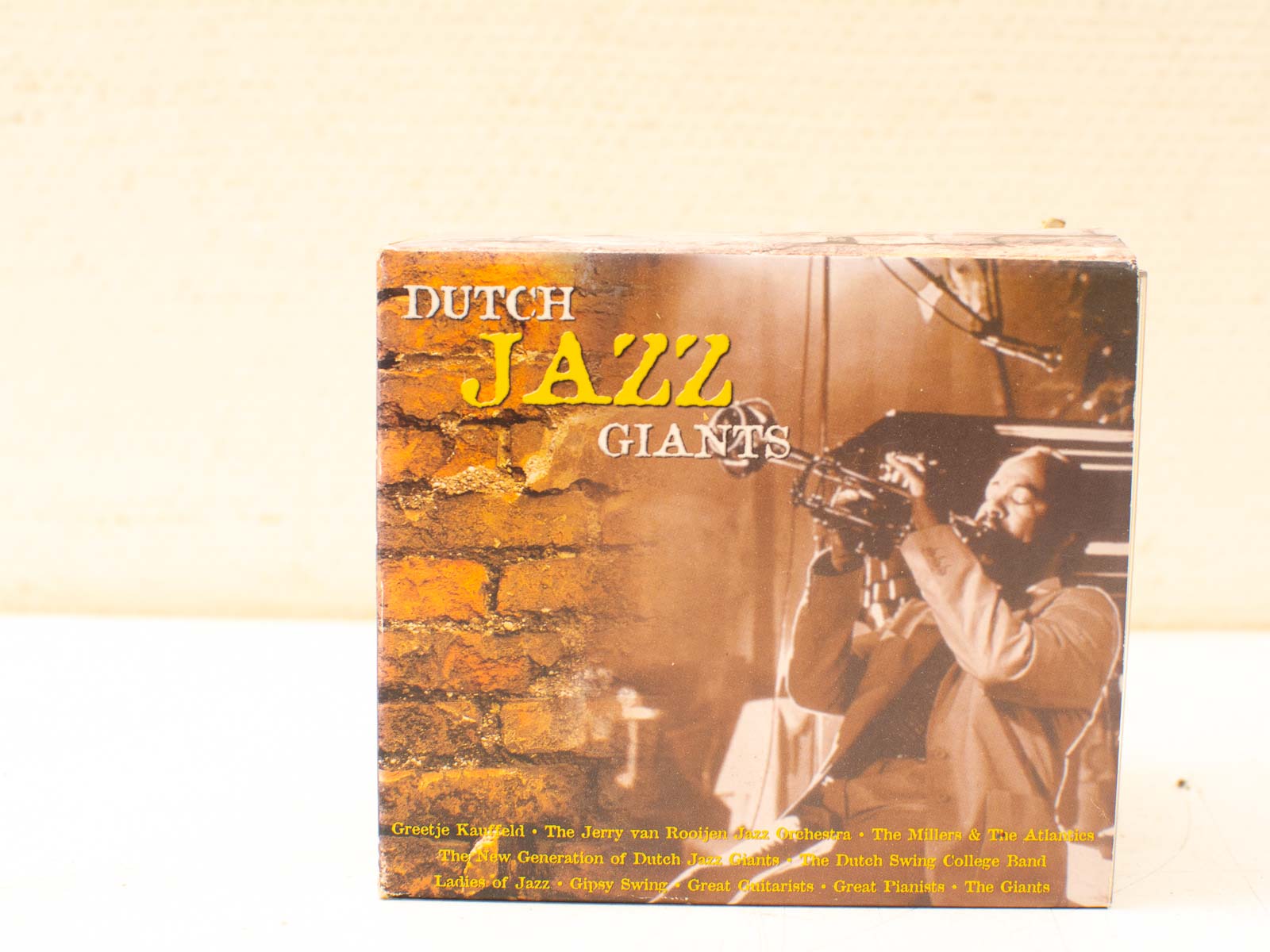 Vibrant Dutch jazz CD cover featuring a trumpet player against a textured brick background.