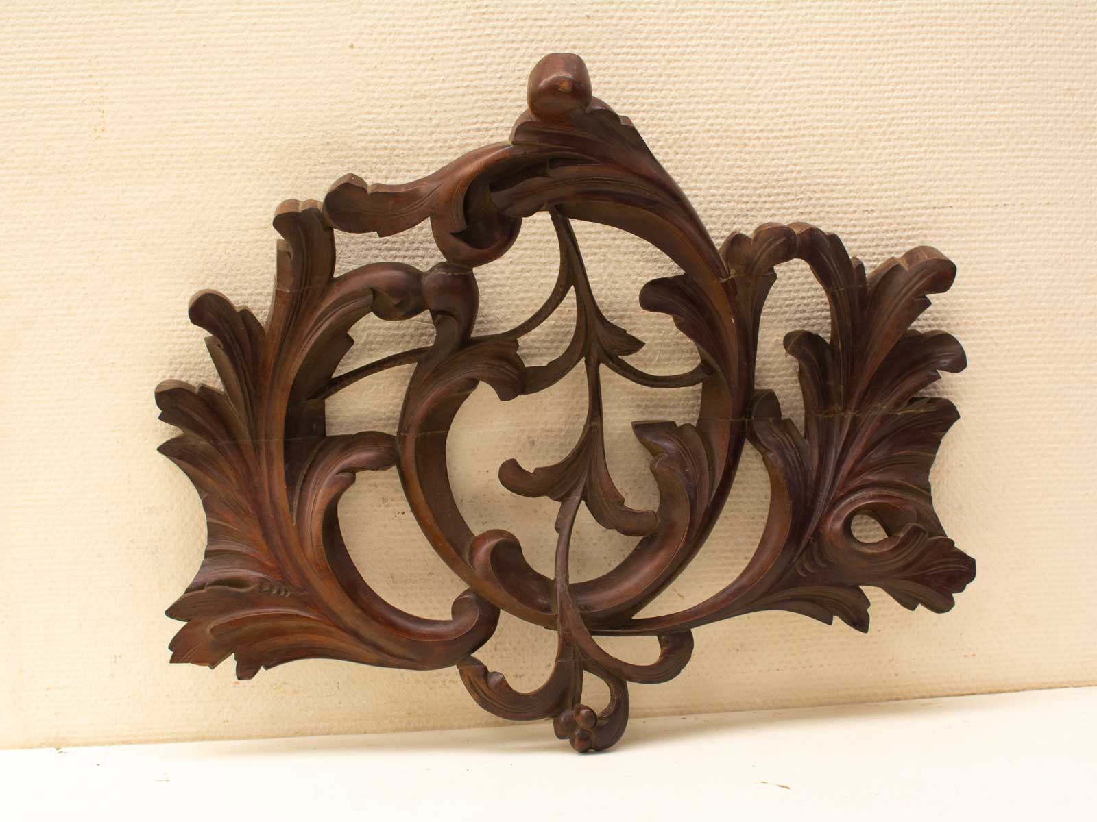 Intricately carved wooden ornament with floral motifs, ideal for traditional decor and elegant spaces.