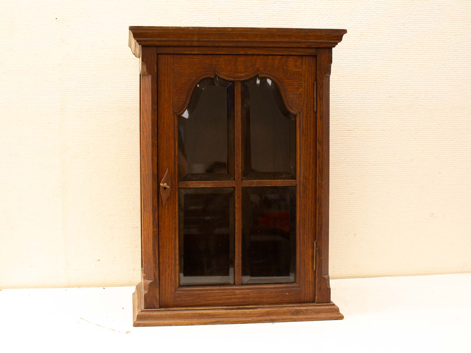 Elegant vintage wooden cabinet with glass doors, perfect for displaying collectibles and adding charm.