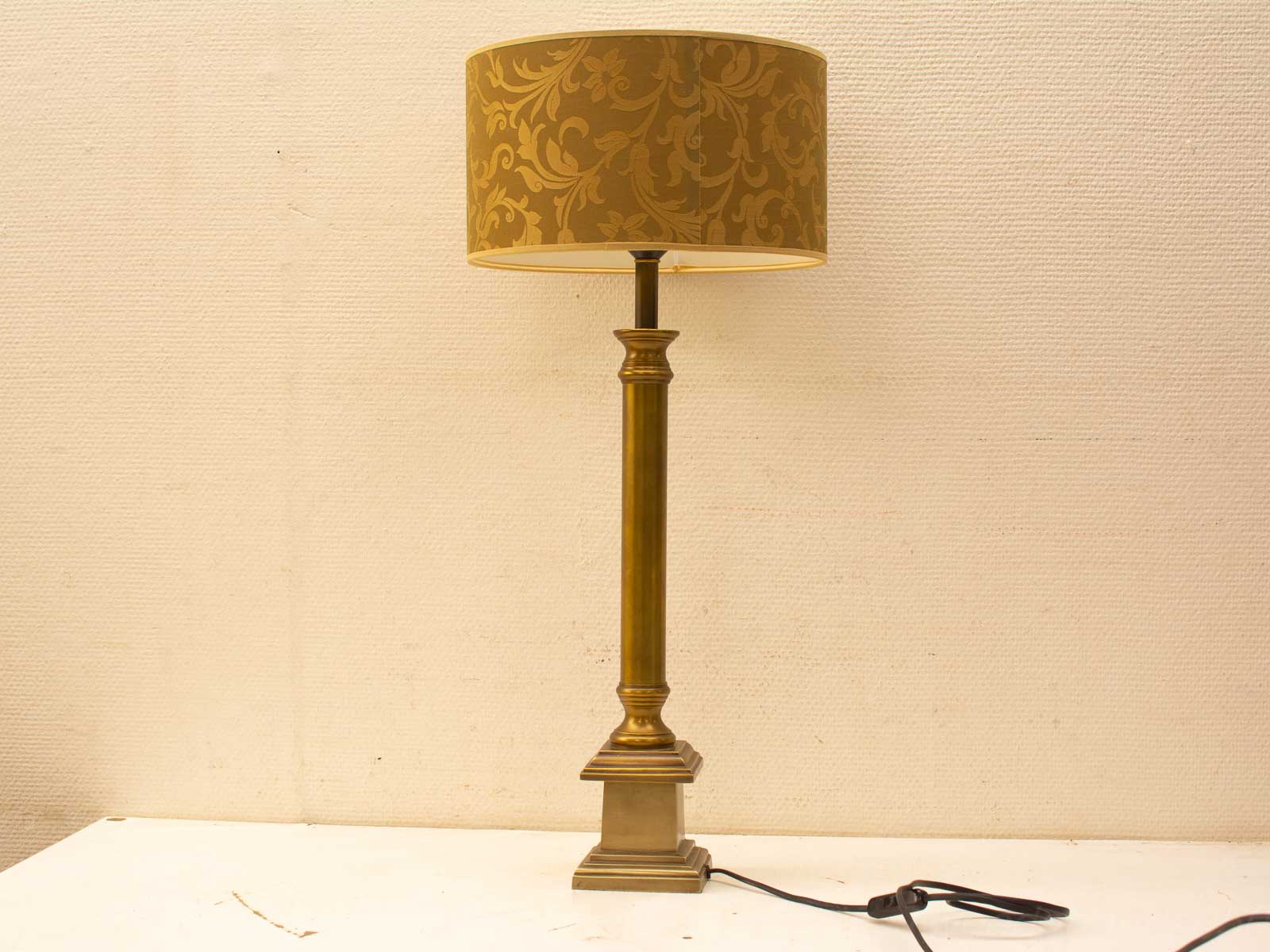 Elegant metallic lamp with golden floral pattern, a stylish and functional addition to any room.