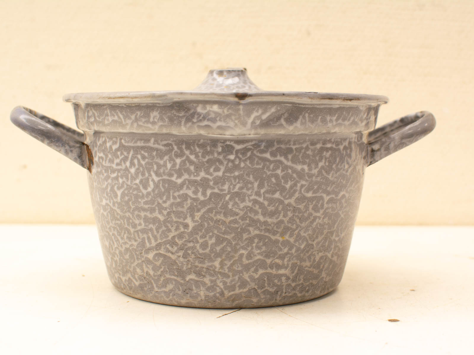 Vintage gray enameled pot with rustic charm, ideal for nostalgic home-cooked meals or kitchen decor.