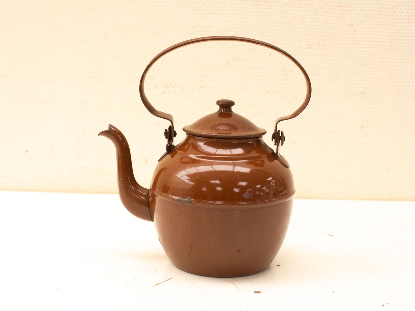 Vintage brown metal teapot with signs of wear, adding nostalgic charm to kitchen decor.