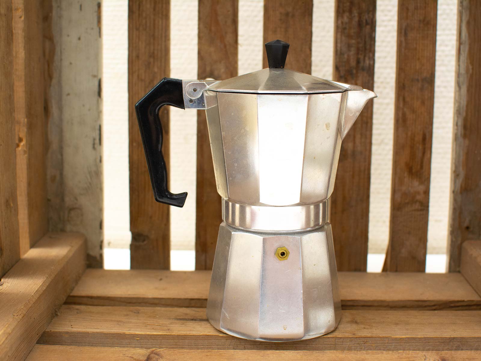 Classic moka pot on rustic wood, perfect for coffee lovers appreciating quality brewing.