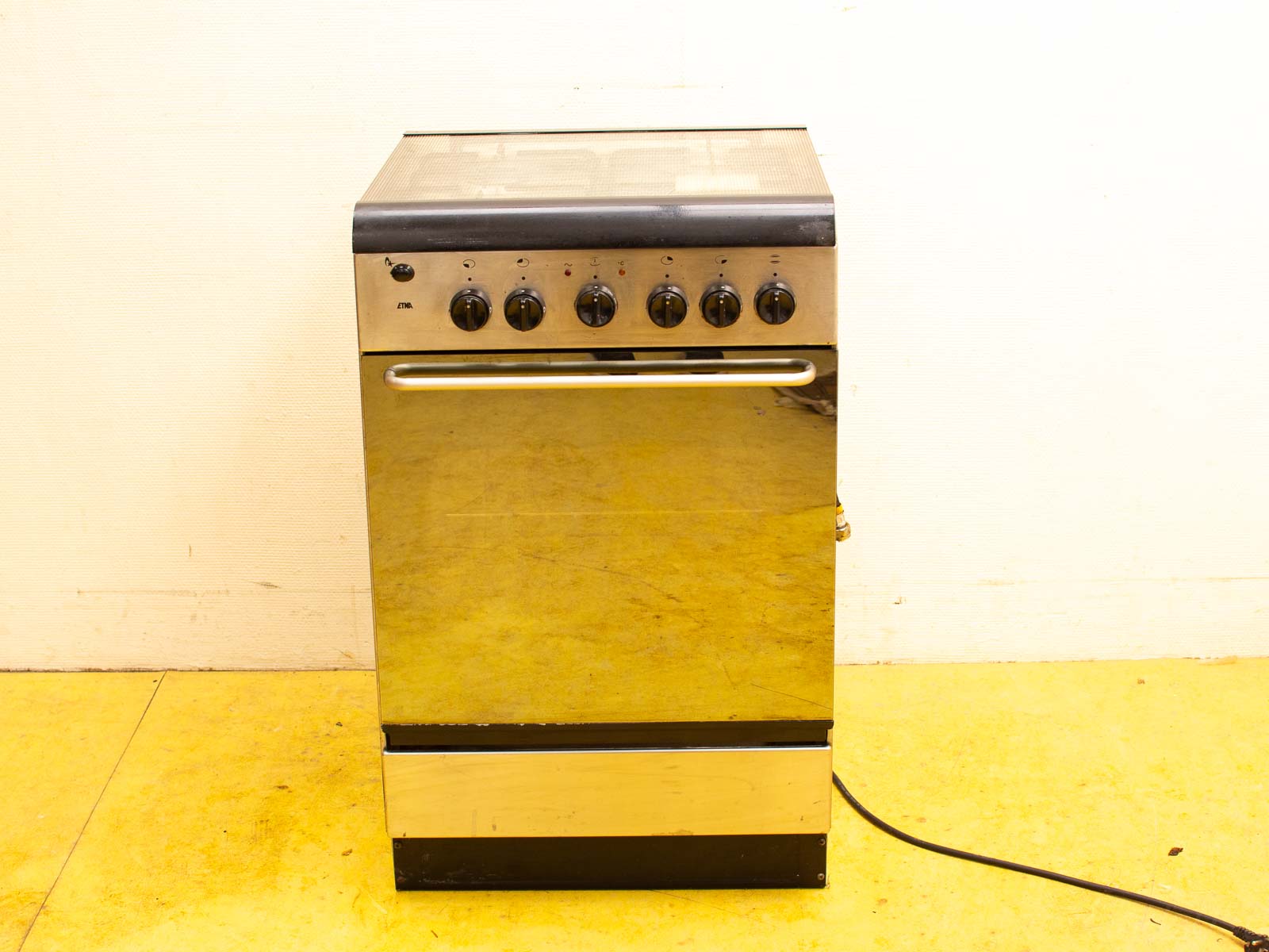 Sleek stainless steel stove with glass top and user-friendly controls for modern kitchens.