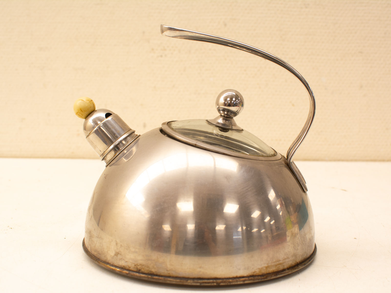 Vintage stainless steel kettle with glass lid and whistle spout, perfect for stylish kitchens.