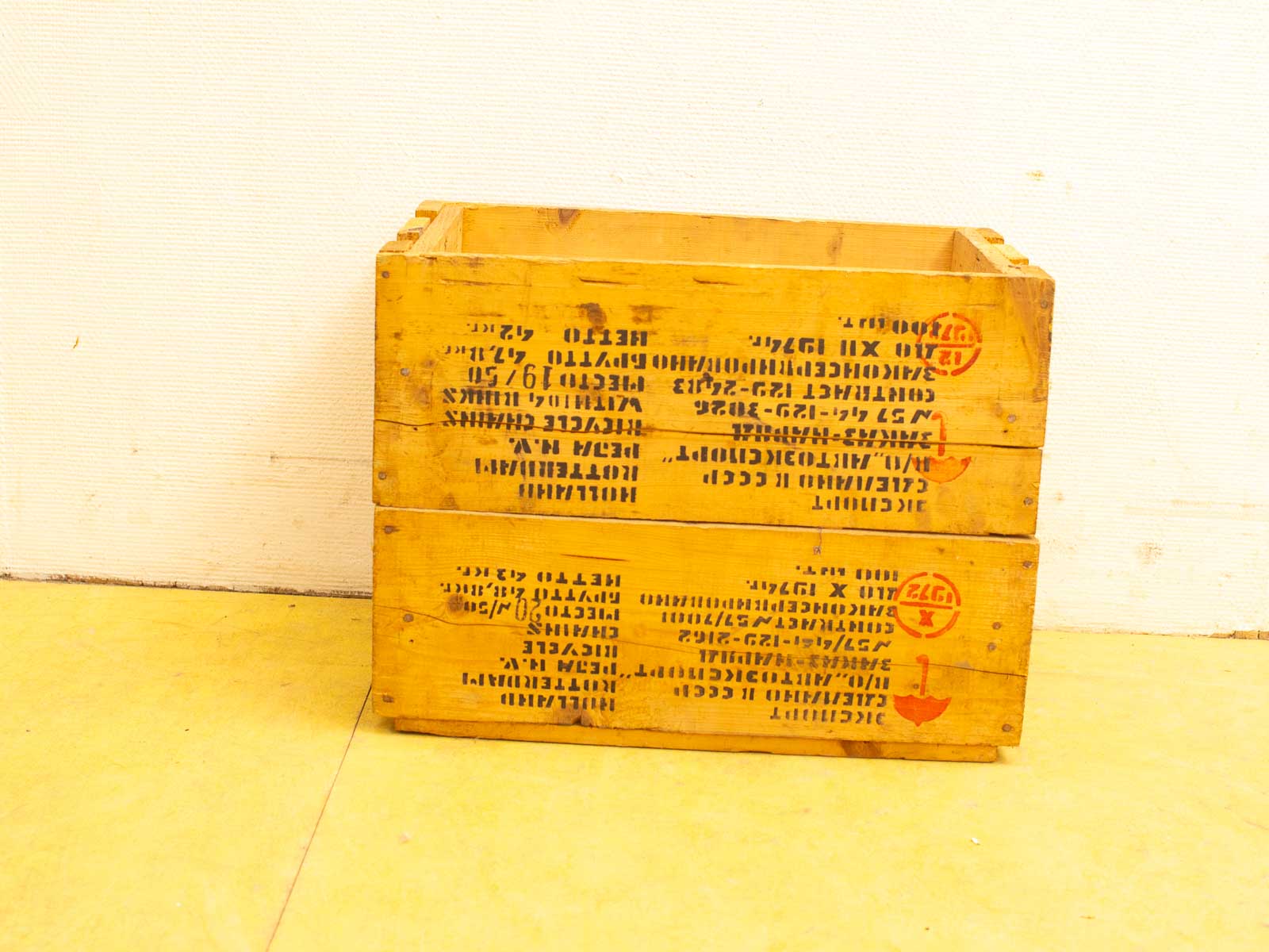 Vintage yellow wooden crate displaying industrial charm and history on a white background.