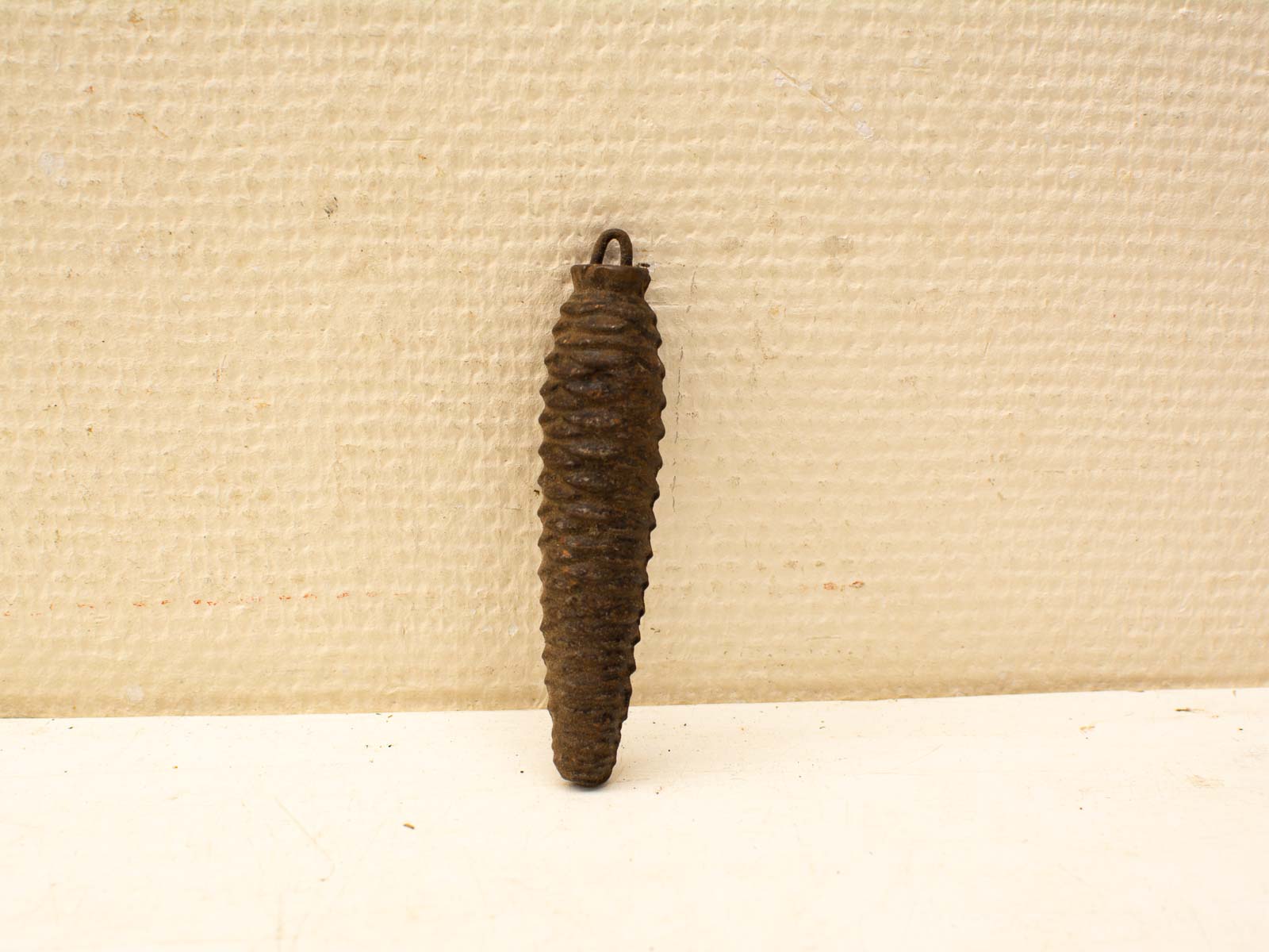 Handcrafted dark metal pinecone pendant with rustic patina and natural-inspired texture.