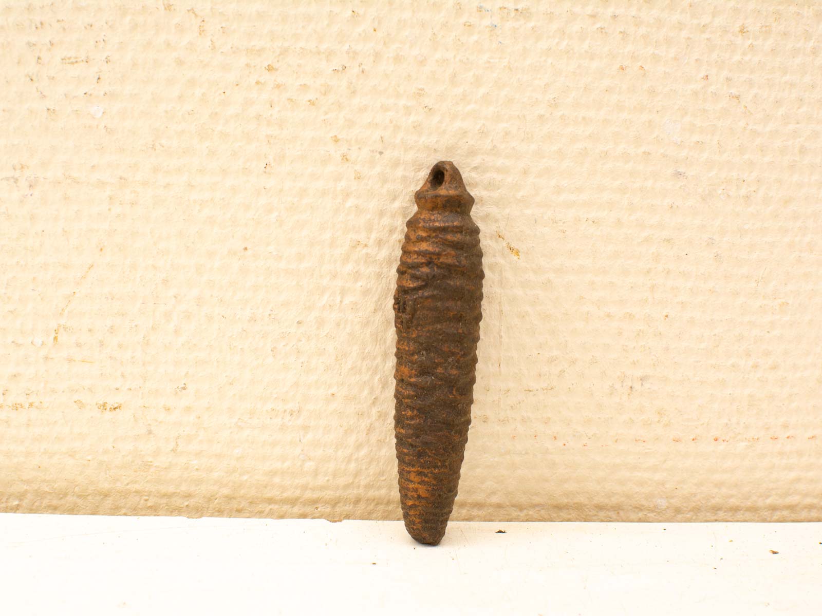 Rusty brown conical metal artifact with spiral ridges, perfect for collectors and home decor.