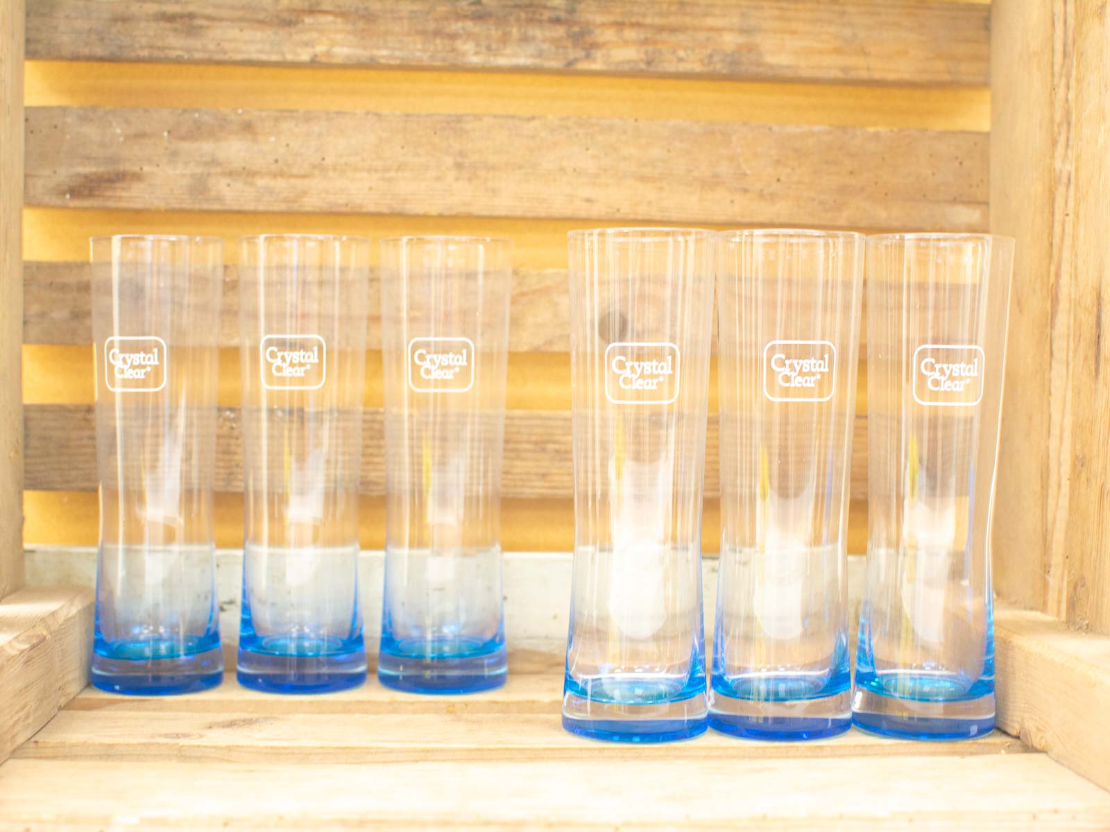 Stylish retro glasses with blue accents showcased on a rustic wooden shelf.