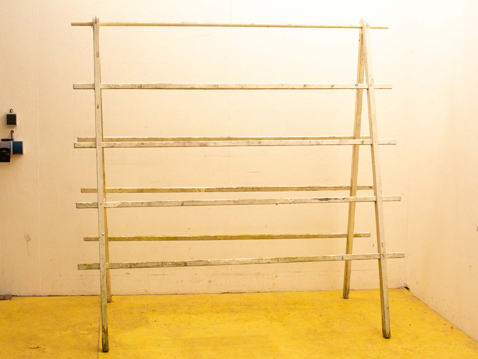 Weathered wooden rack with triangular supports, perfect for rustic storage or display in any space.