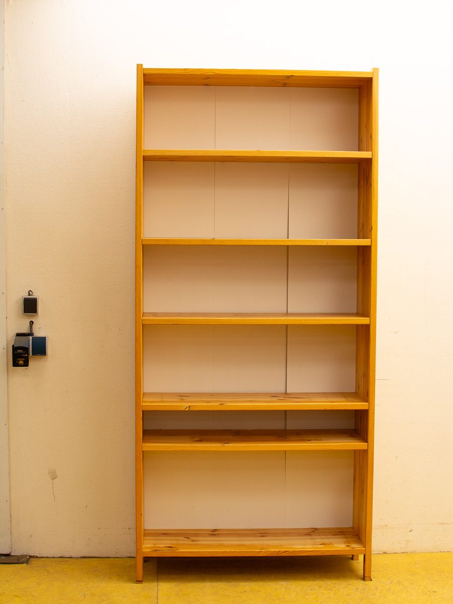 Minimalist pine bookshelf in a bright interior with a vibrant yellow floor