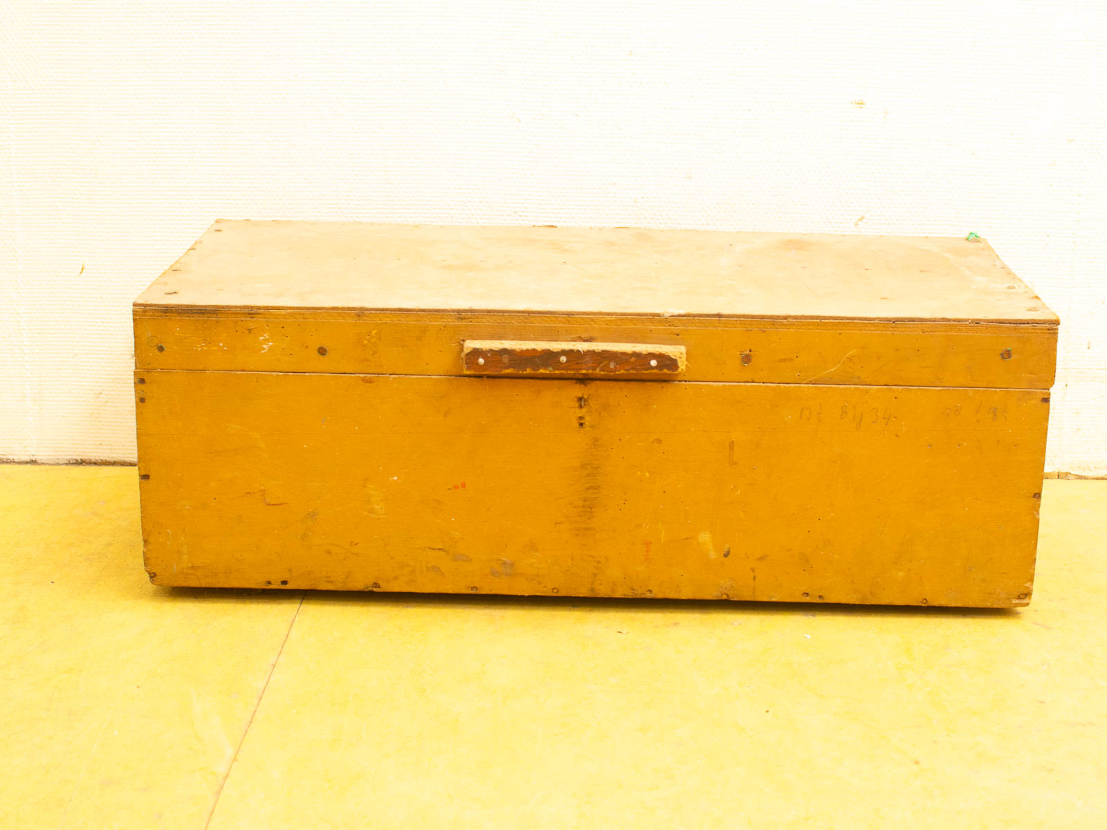 Vintage yellow wooden storage box with rustic charm and signs of age, perfect for decor.