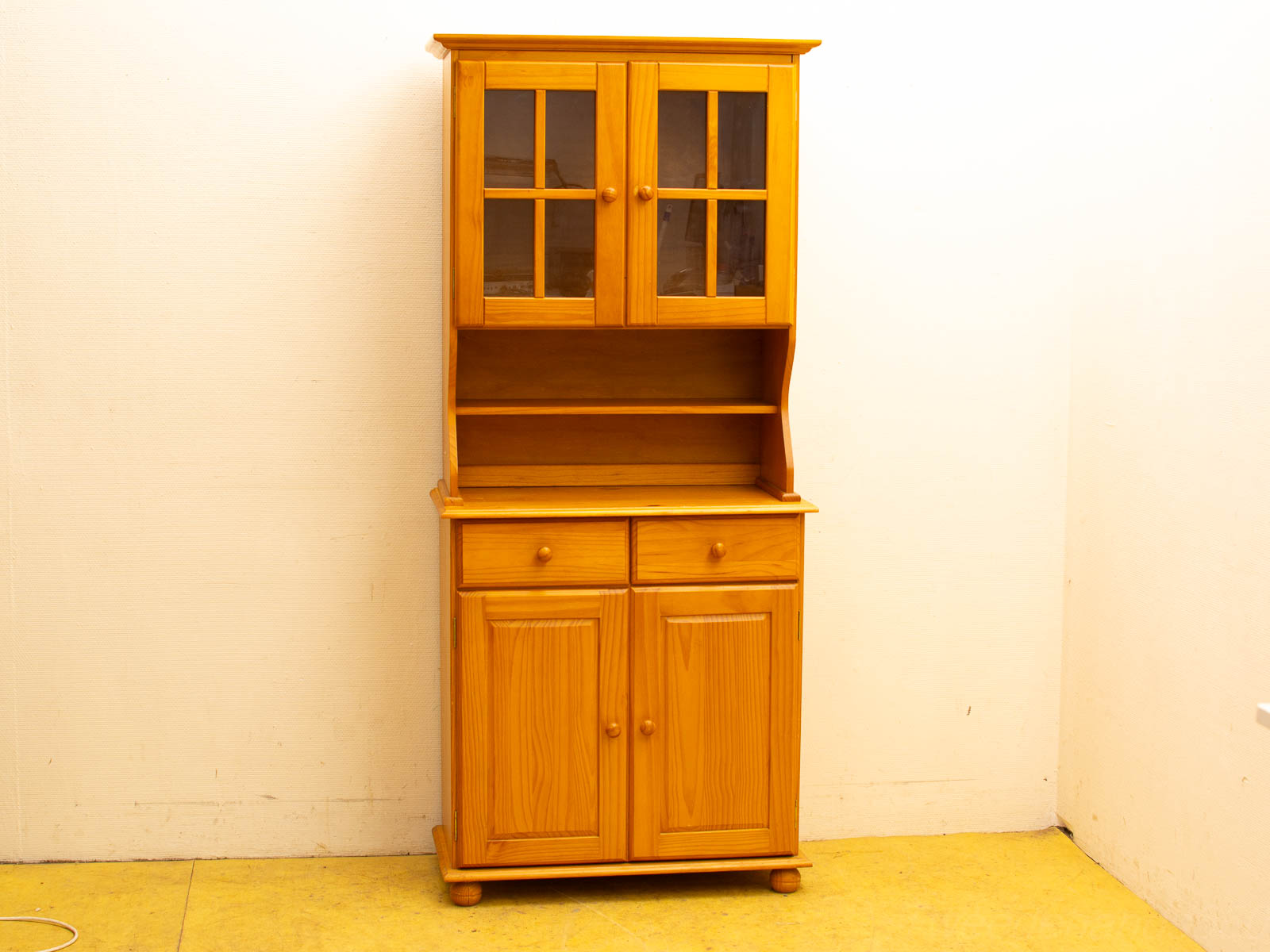 Warm wooden cabinet with glass doors and drawers, perfect for storage and display.