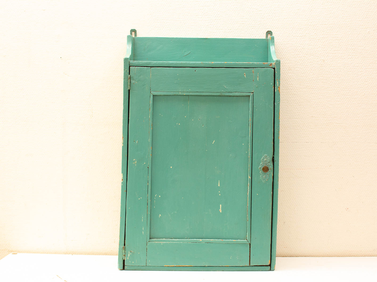 Charming vintage turquoise cabinet with distressed wood, perfect for rustic storage or display.