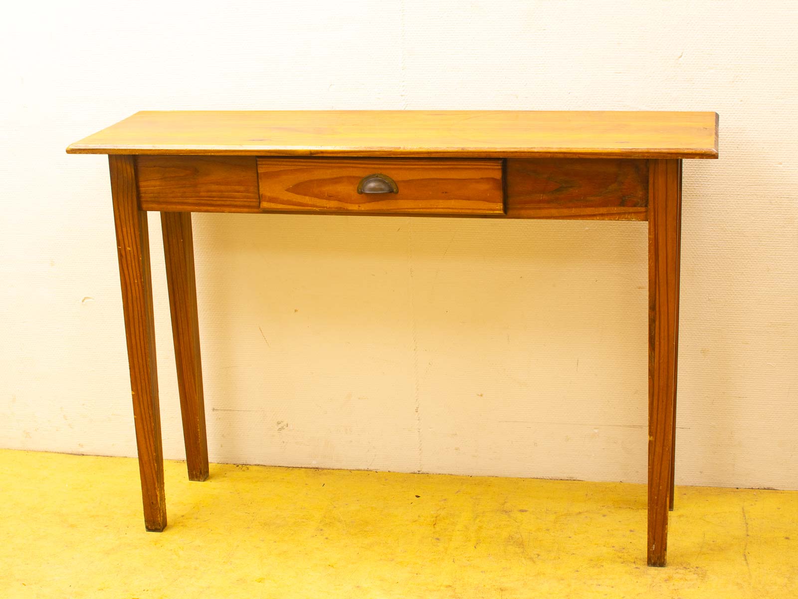 Elegant wooden table with drawer, featuring a minimalist design and warm natural finish.