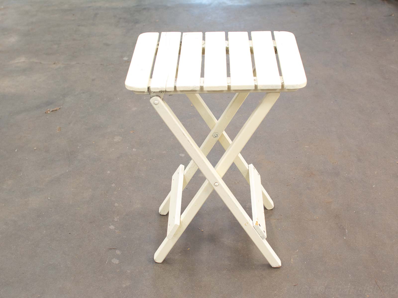 Elegant white folding table with wooden slats, perfect for indoor or outdoor use.