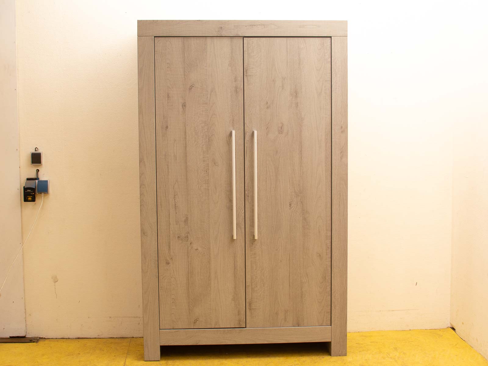 Modern light wood wardrobe with sleek design, polished finish, and vibrant yellow flooring.