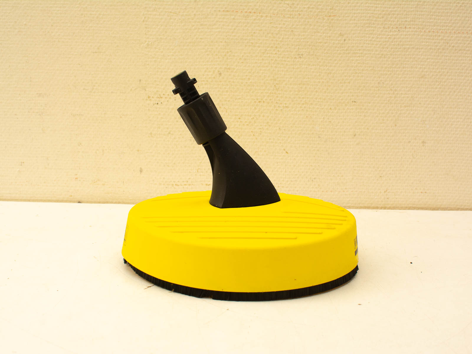 Efficient pressure washer attachment with yellow base and black bristles for versatile cleaning tasks.