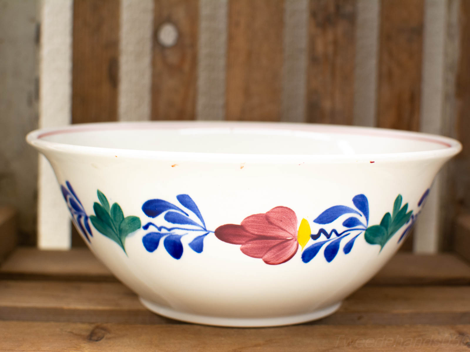 Artistic handmade ceramic bowl with vibrant floral design, perfect for rustic table settings.