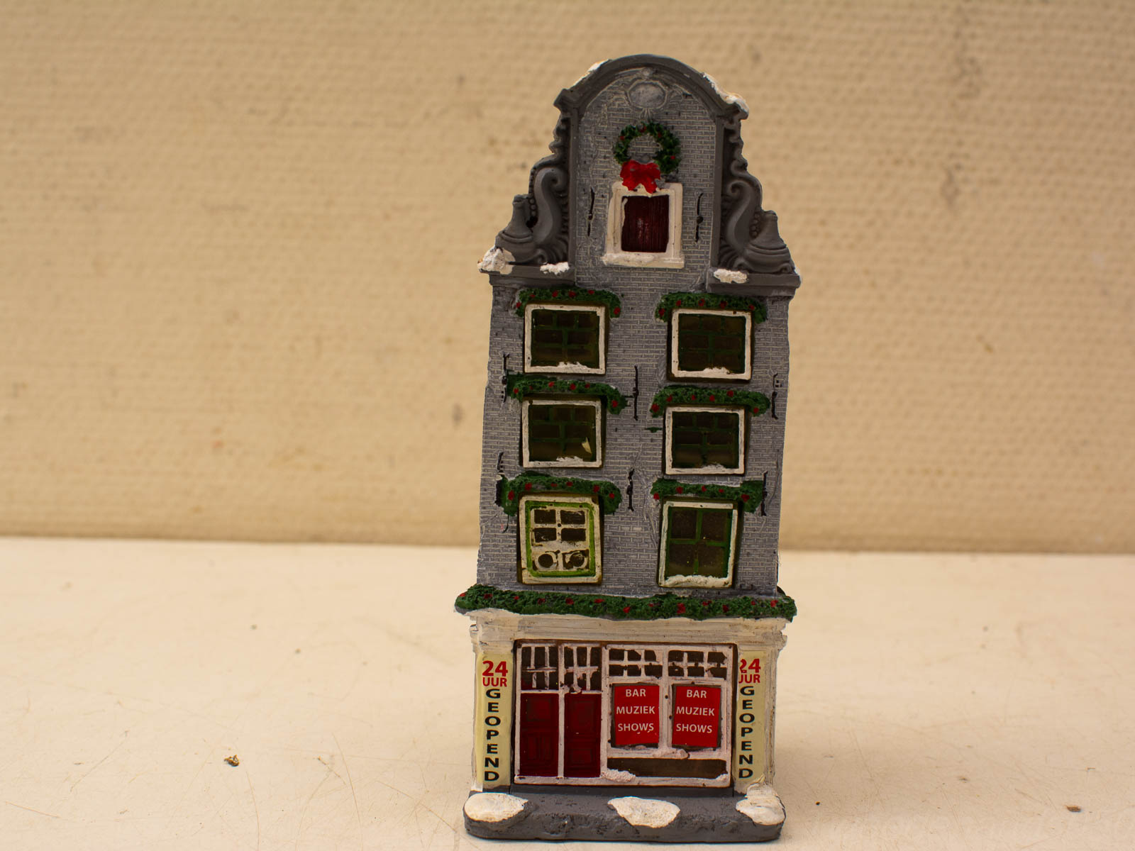 Charming miniature Dutch house with winter decorations, red doors, and festive wreath for holiday displays.