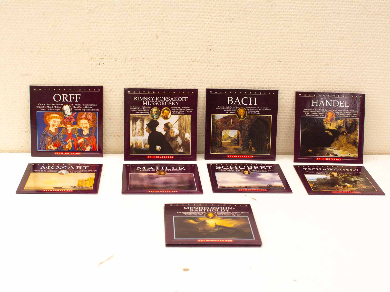 Curated classical music album collection featuring iconic composers with vibrant maroon and gold designs.