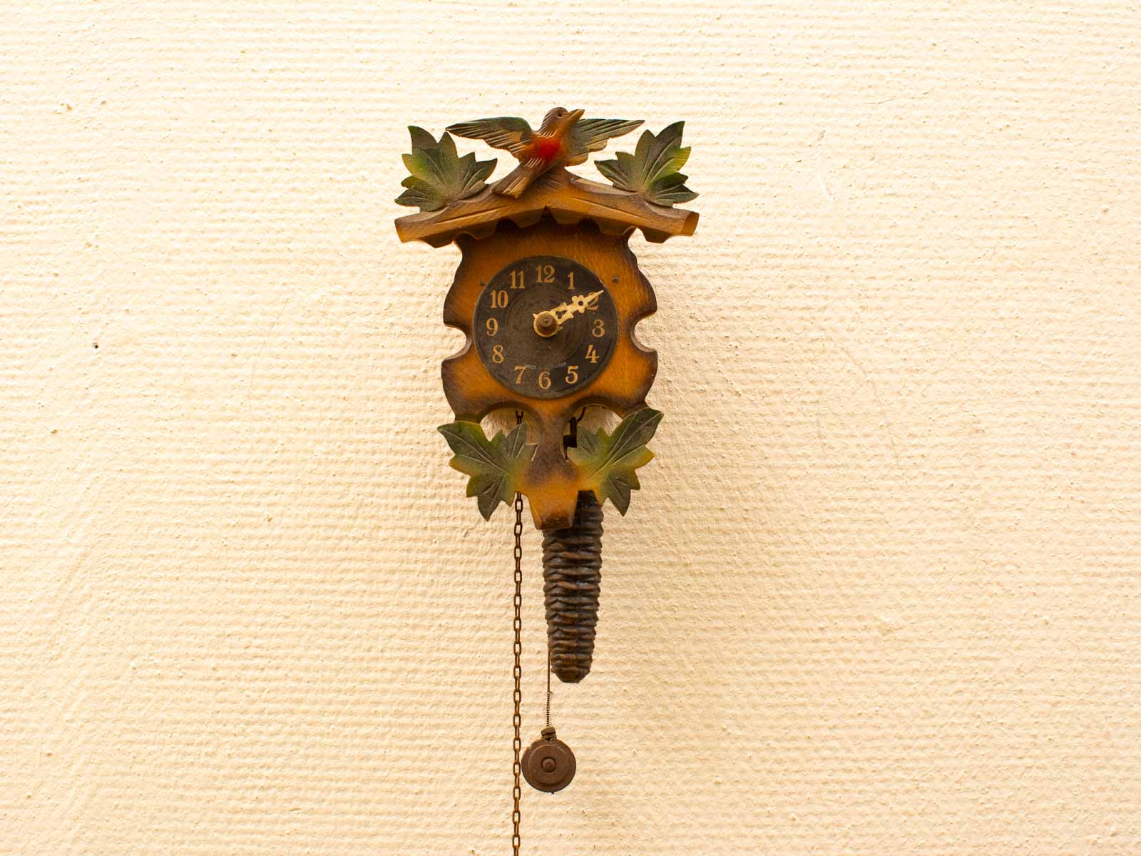 Traditional wooden cuckoo clock with vibrant nature motifs for a charming home decor piece.