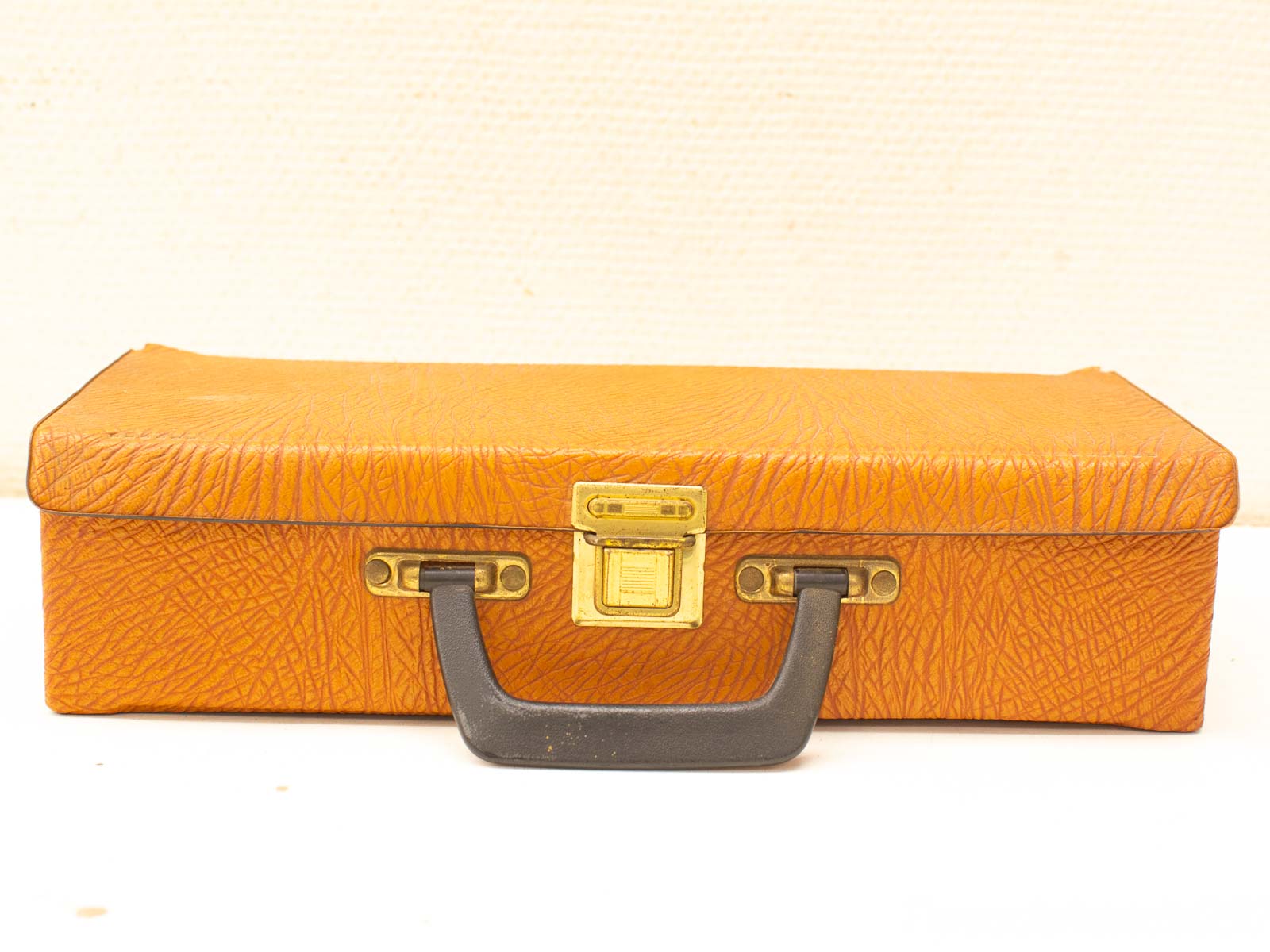 Retro orange briefcase with golden clasp and durable handle, perfect for stylish storage.