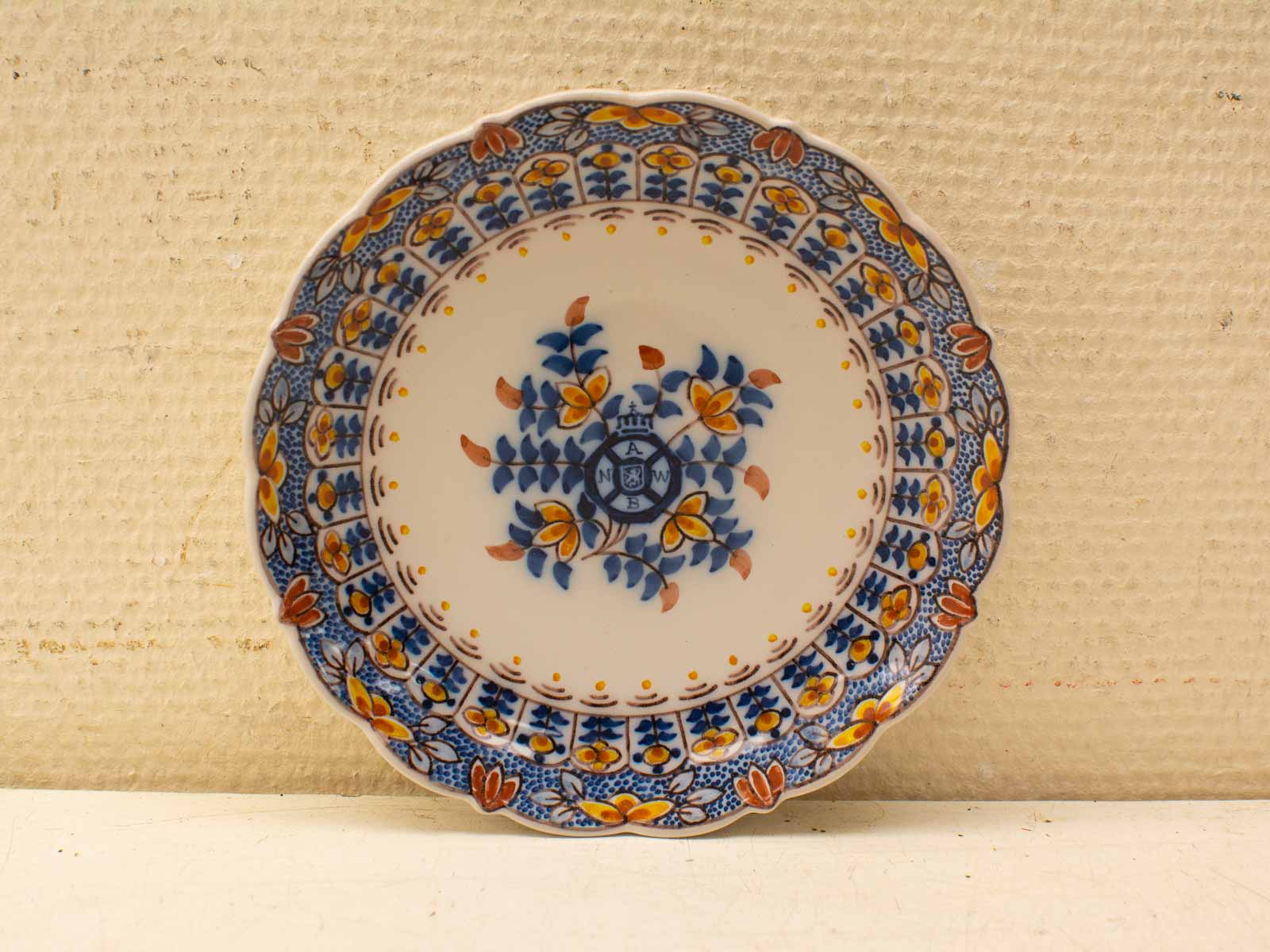 Vibrant hand-painted decorative plate with scalloped edge and floral motif in bright colors.