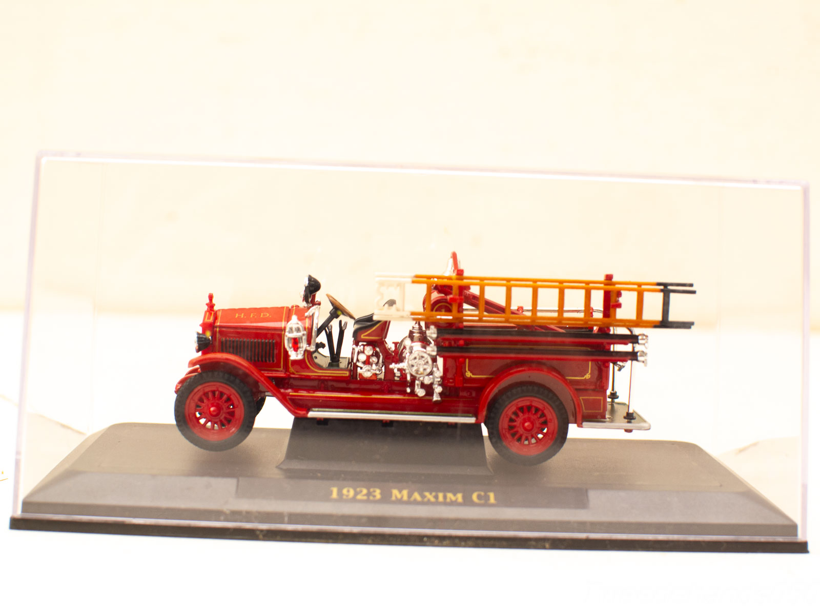 1923 Maxim C1 fire truck model in display case, showcasing vintage firefighting craftsmanship and history.