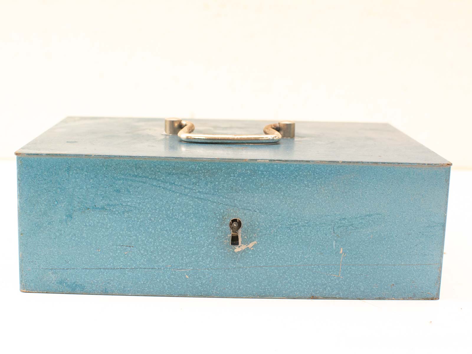 Vintage blue metal box with handle and keyhole, perfect for secure storage and decor.